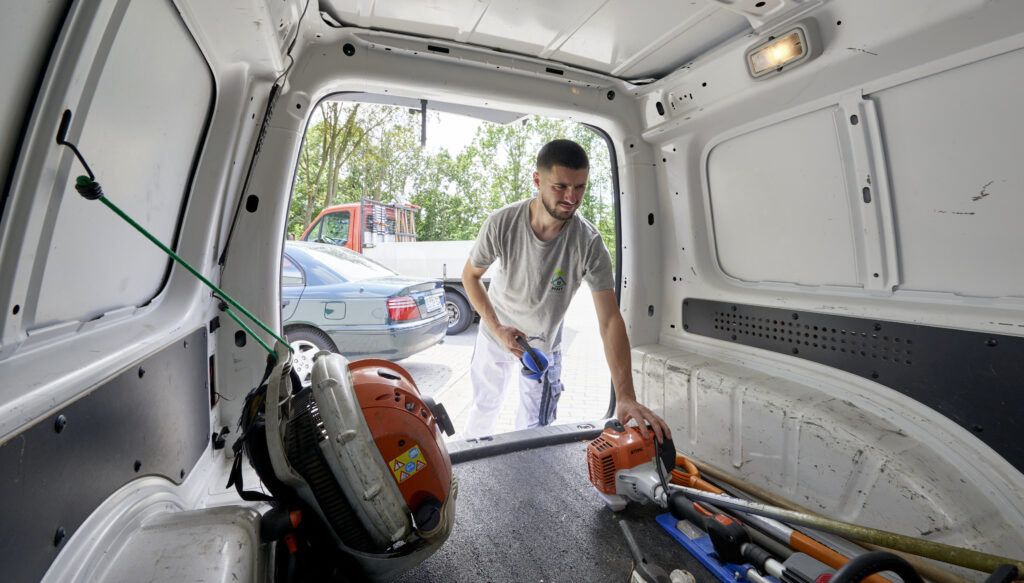 MMT Mitarbeiter mit Gartengeräten am Transporter